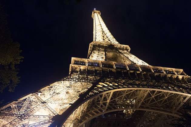A view from under the Eiffel Tower in Paris at night.
