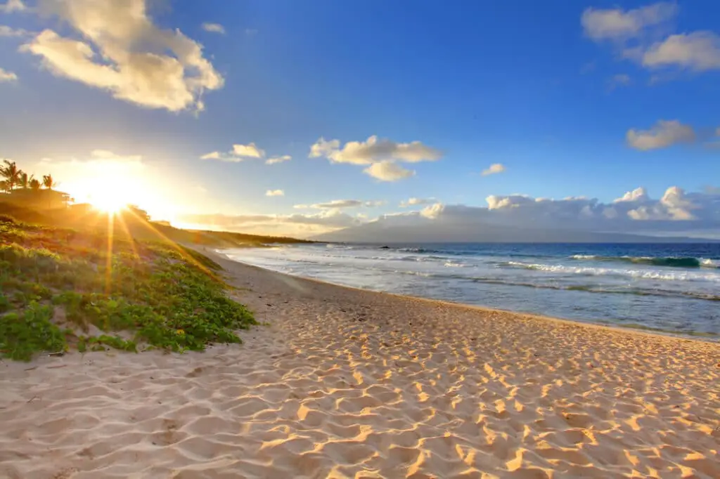 Sunrise over the Maui coastline with the sun rising above the ocean horizon.